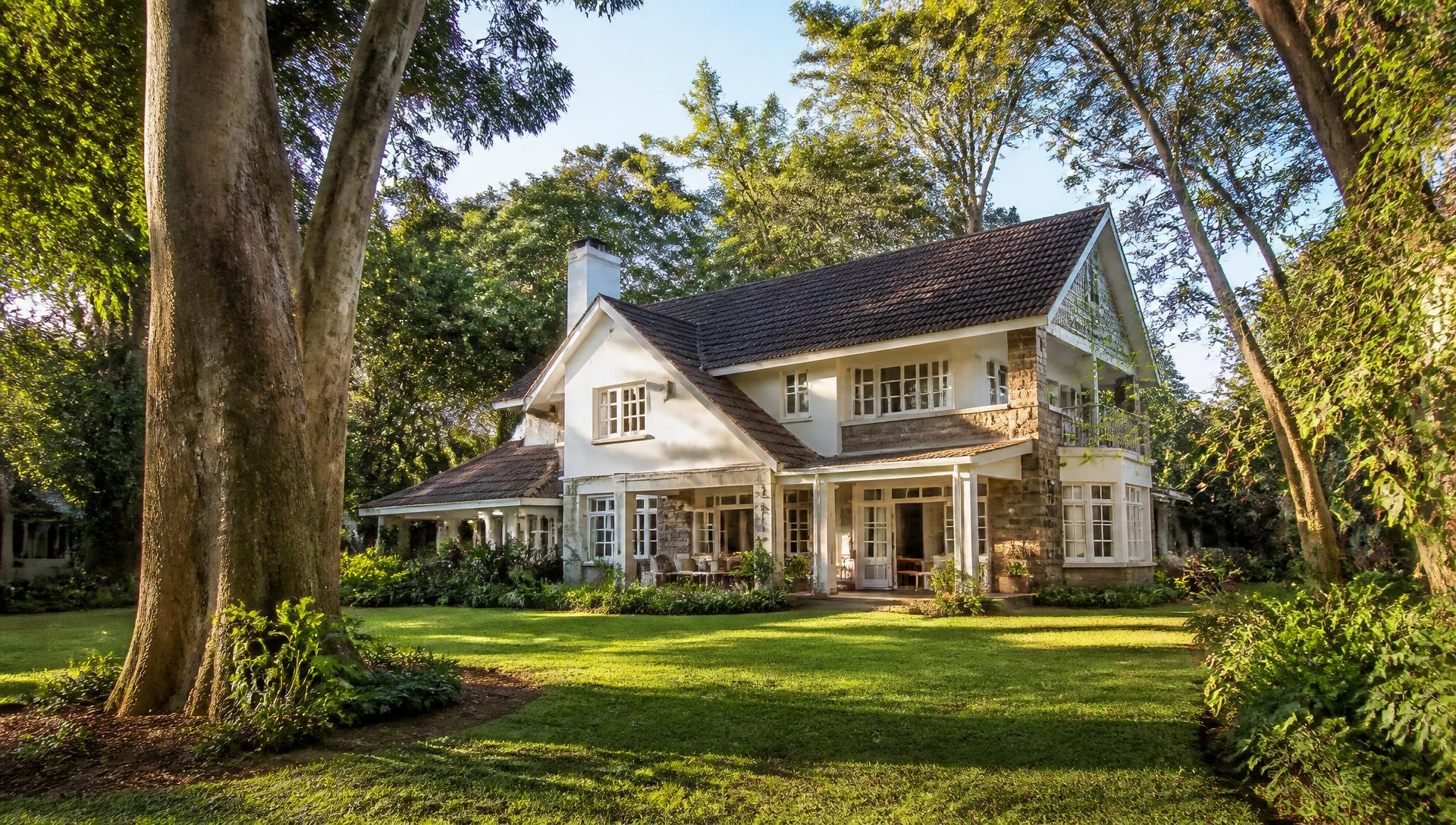 Family house behind mature garden trees in Lavington